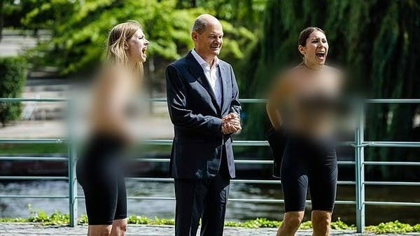 Two activists surprised the German chancellor with a naked chest