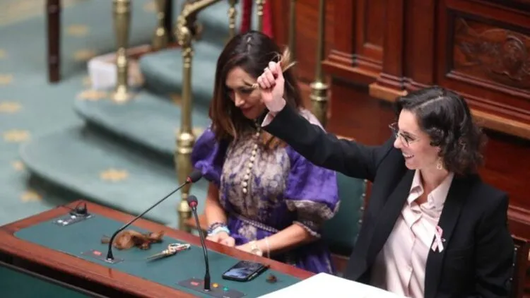 Belgium’s foreign minister cuts a lock of her hair in support of Iranian women