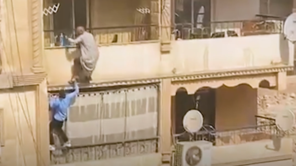 Video .. An Egyptian student puts himself at risk to save an elderly from a fire