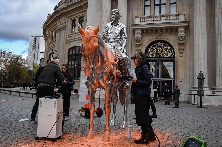 Environmental activists spraying the paint on the Charles Ray statue in Paris